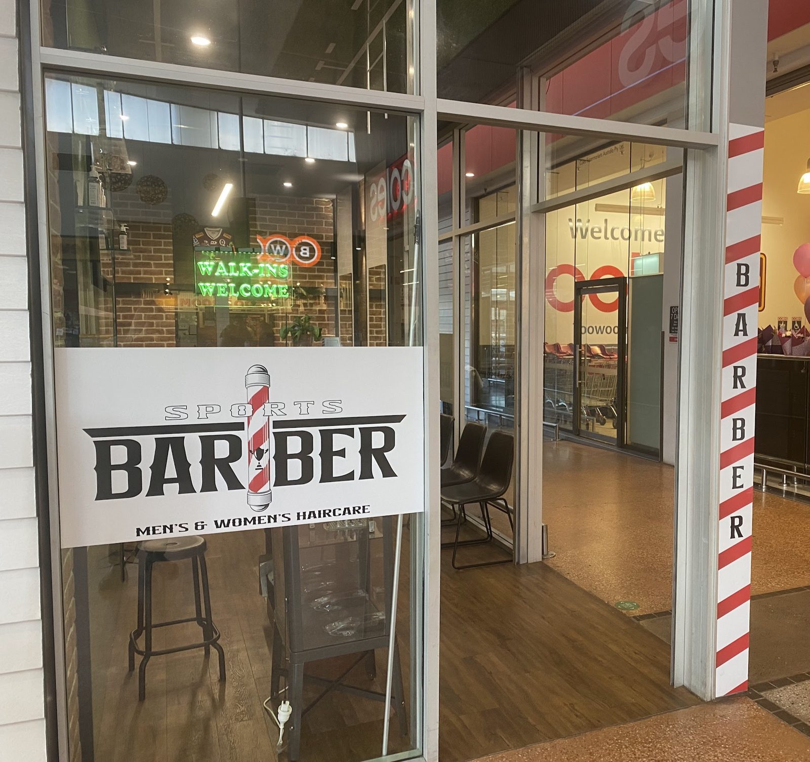 Sports Barber from the Northpoint mall walkway, barber pole stripes and neon sign