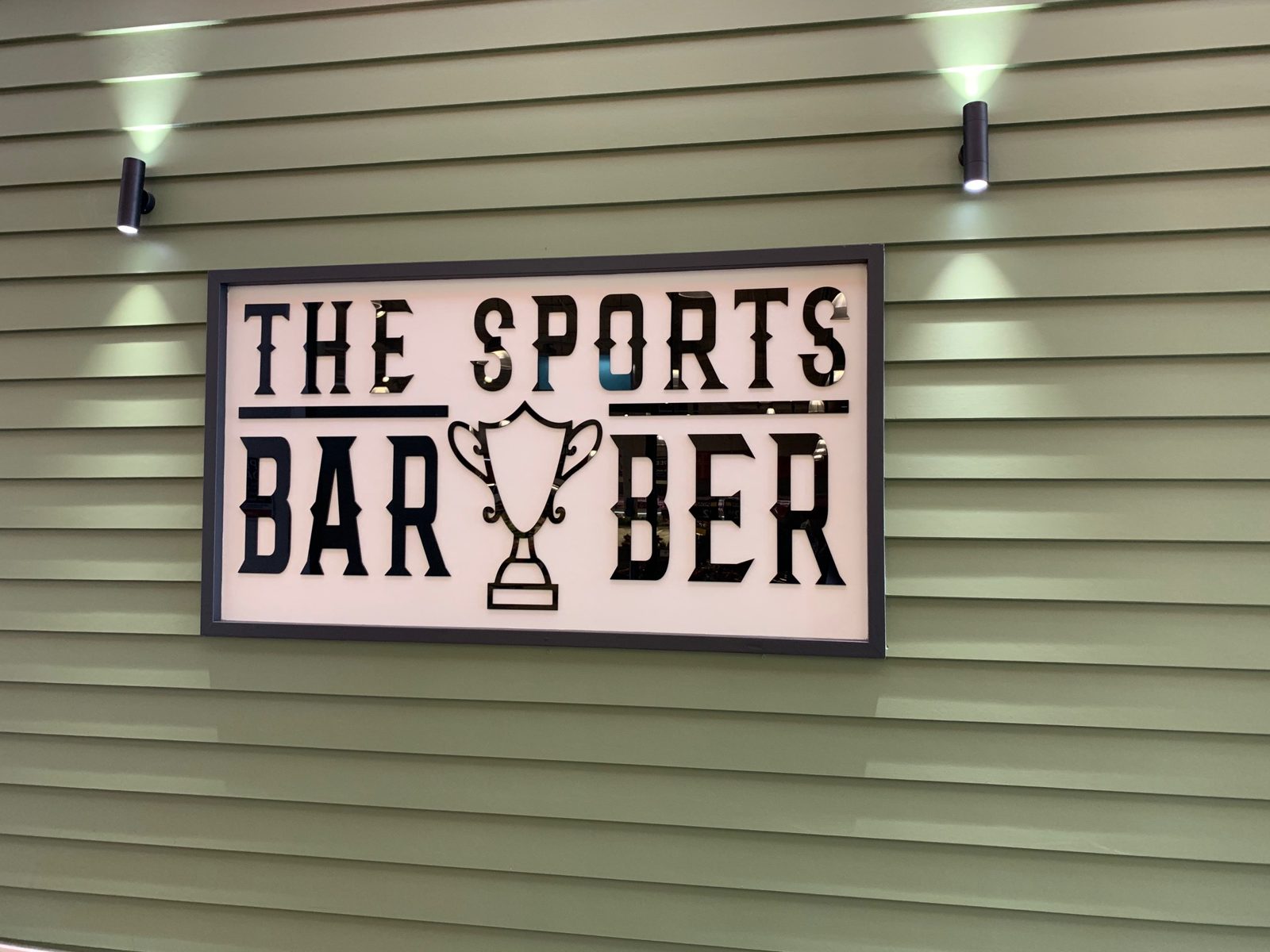 The Sports Barber wall sign with its trophy logo